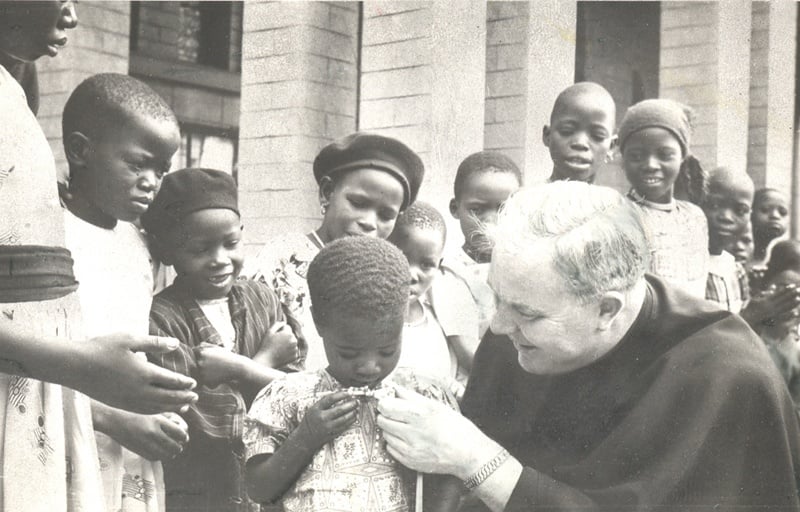 Father Peyton explains the Rosary to a little girl in Africa.