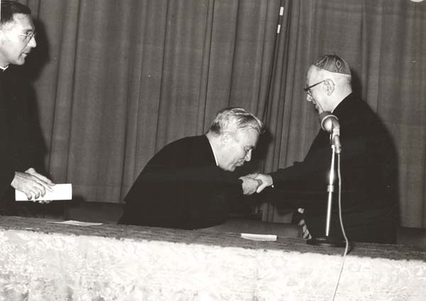 Father Joseph Quinn, C.S.C., looks on as Father Peyton greets the Cardinal.