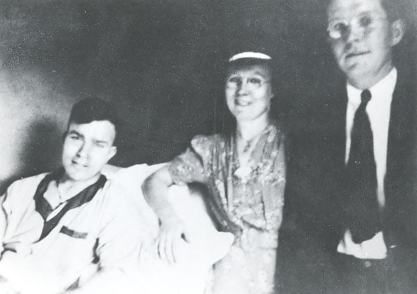 Patrick in the infirmary, with his sister Nellie and brother Tom at his bedside.